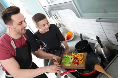 Dad and son cooking together in kitchen