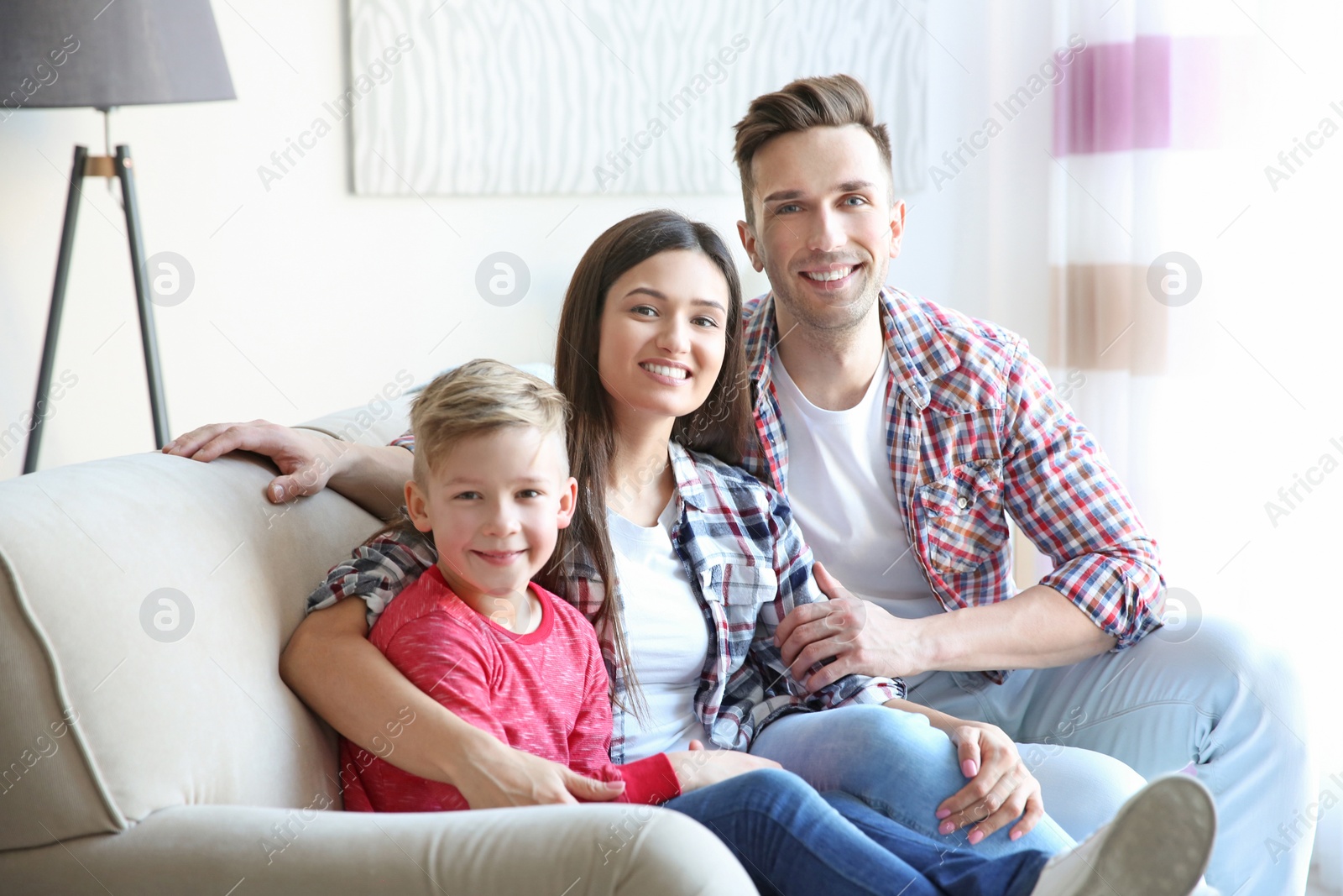 Photo of Happy family sitting on sofa, indoors