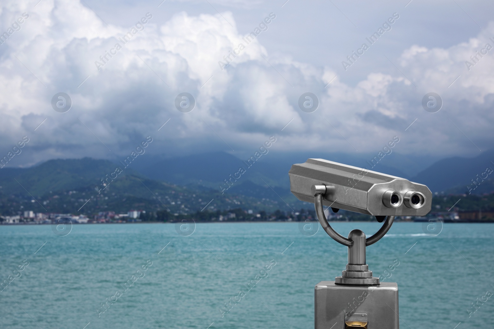 Photo of Metal tower viewer installed near sea, space for text. Mounted binoculars