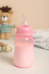 Photo of Feeding bottle with milk on white table