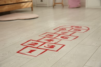 Photo of Red hopscotch floor sticker in room, closeup