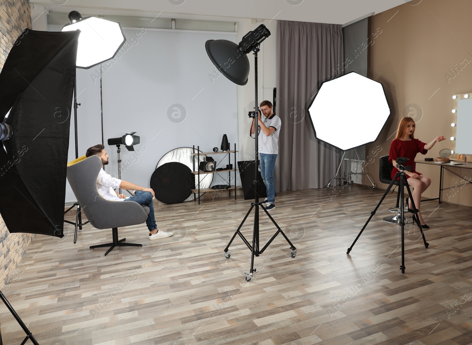 Photo of Photo studio with professional equipment and team of workers