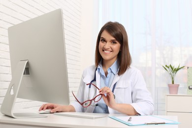 Photo of Pediatrician working with computer at table in clinic