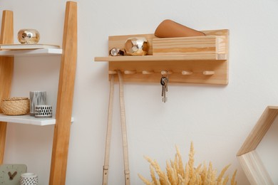 Stylish hanger for keys on white wall in hallway