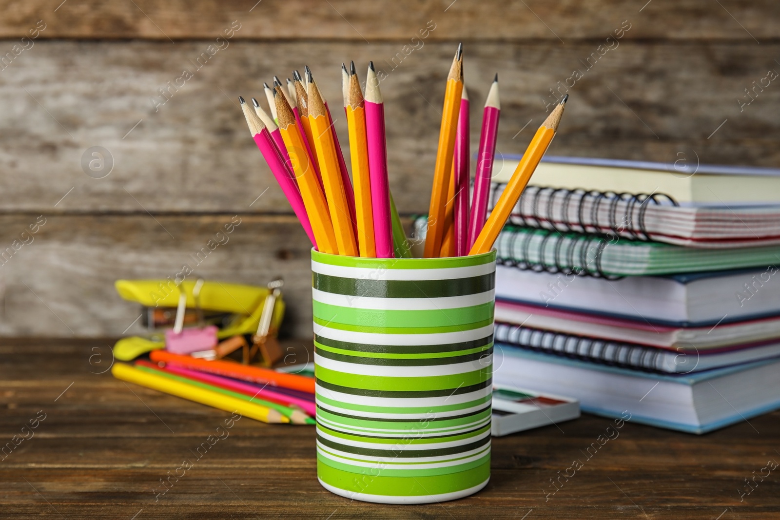 Photo of Different school stationery on table against wooden background