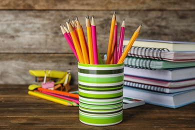 Photo of Different school stationery on table against wooden background