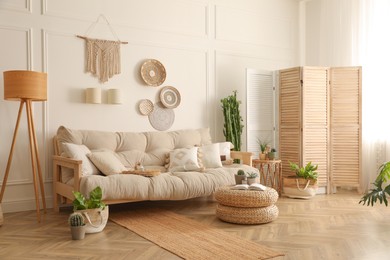 Stylish living room interior with comfortable wooden sofa and beautiful houseplants