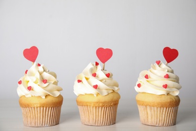 Photo of Tasty sweet cupcakes on white table. Happy Valentine's Day