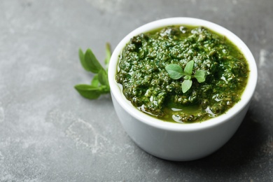 Photo of Homemade basil pesto sauce in bowl on table