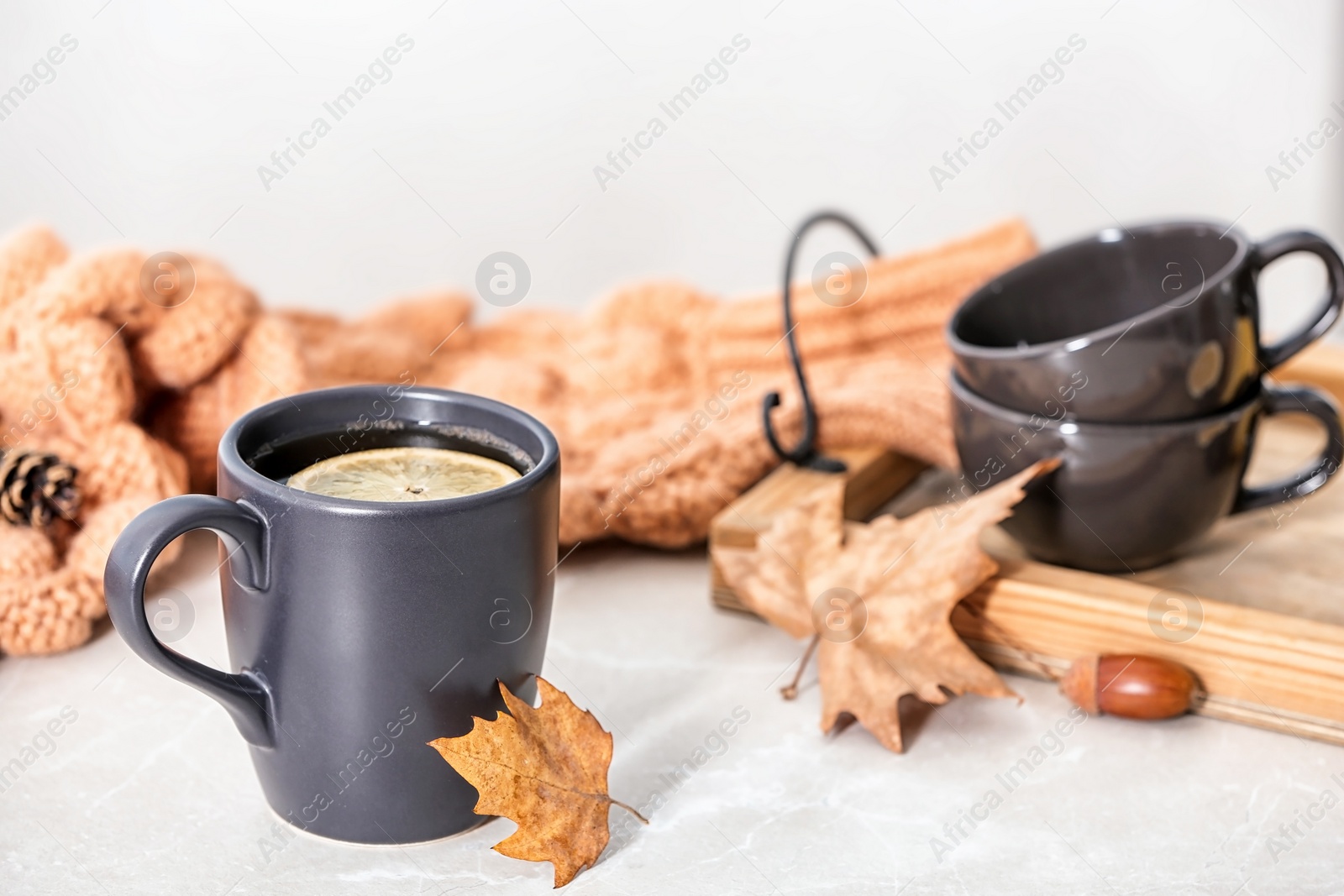 Photo of Composition with hot cozy drink and autumn leaves on table