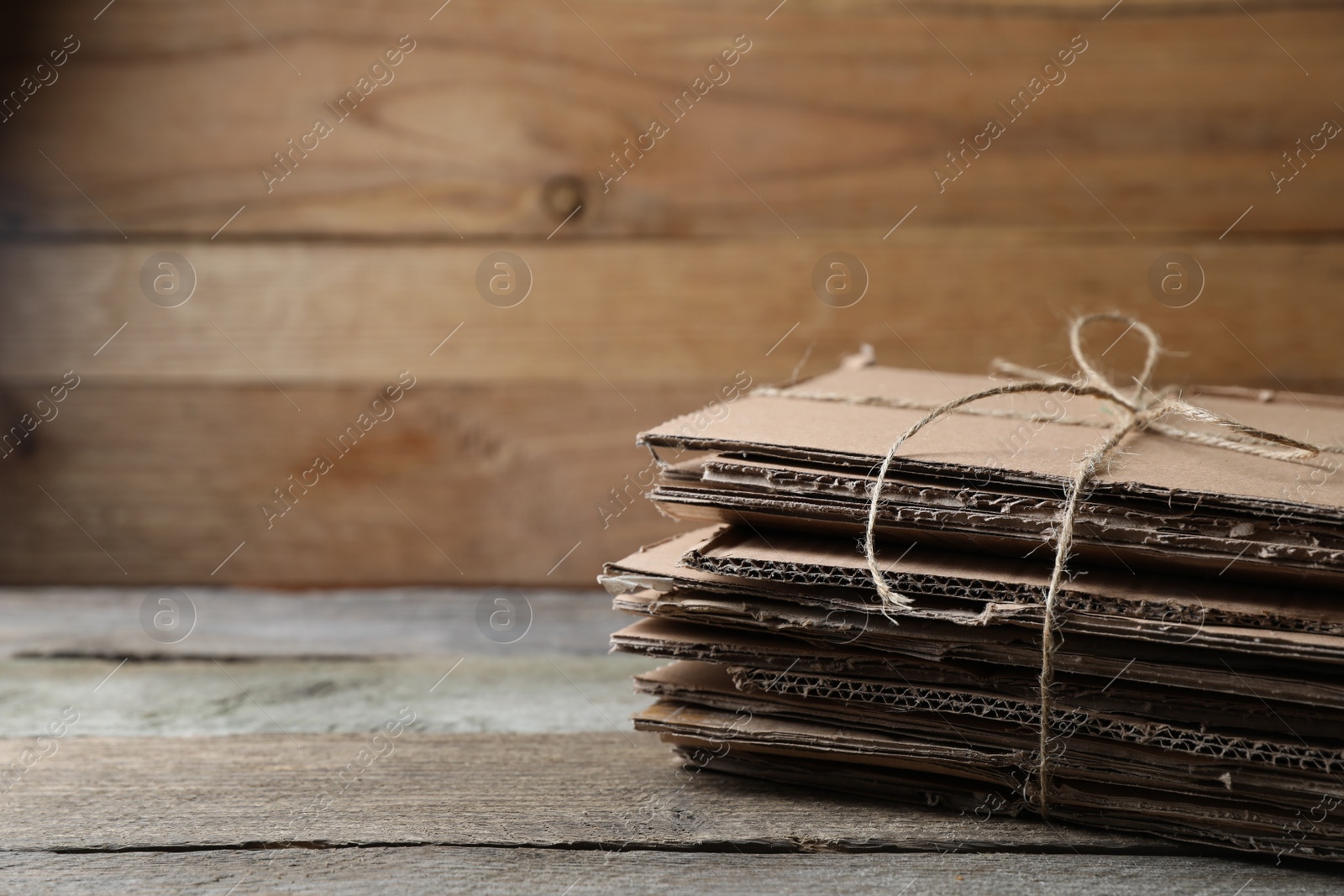 Photo of Stack of waste paper on wooden table, closeup. Space for text