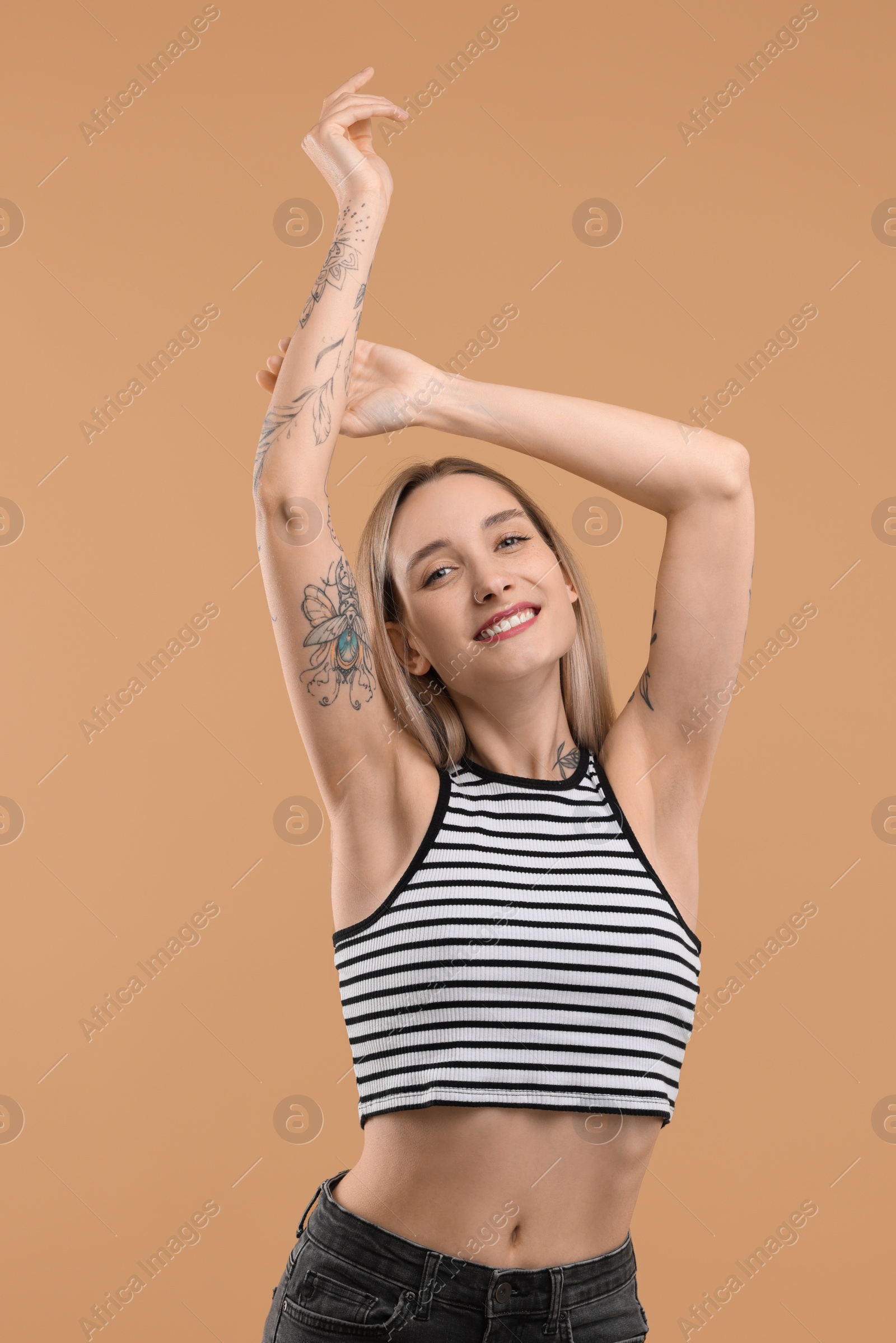 Photo of Portrait of beautiful tattooed woman on beige background