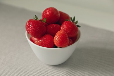 Fresh juicy strawberries in bowl on table, closeup