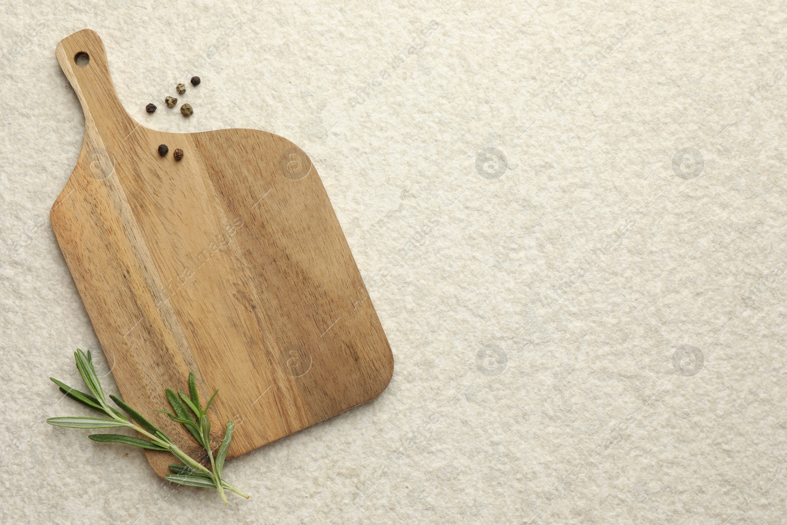 Photo of Cutting board, pepper and rosemary on white textured table, flat lay. Space for text