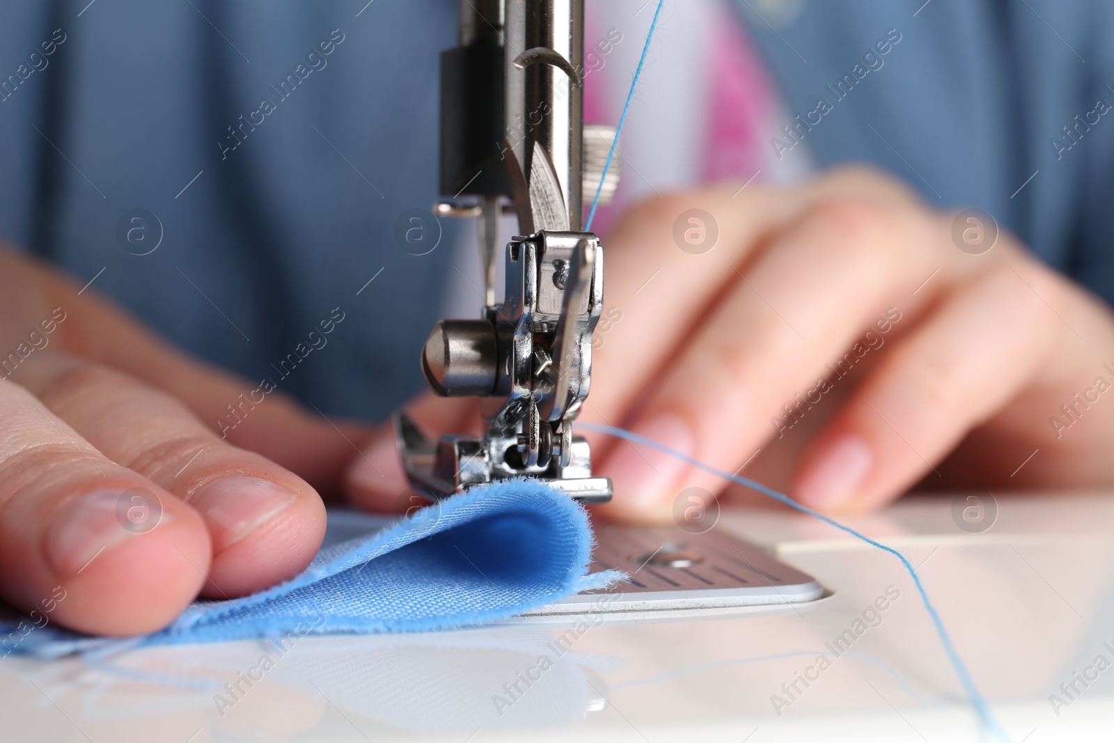 Photo of Seamstress working with sewing machine indoors, closeup