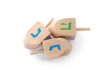 Wooden Hanukkah traditional dreidels with letters He and Nun on white background, top view