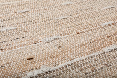 Photo of Stylish beige rug as background, closeup. Interior accessory