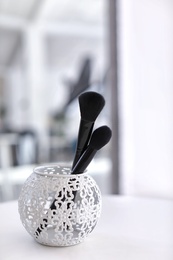 Photo of Holder with makeup brushes on table