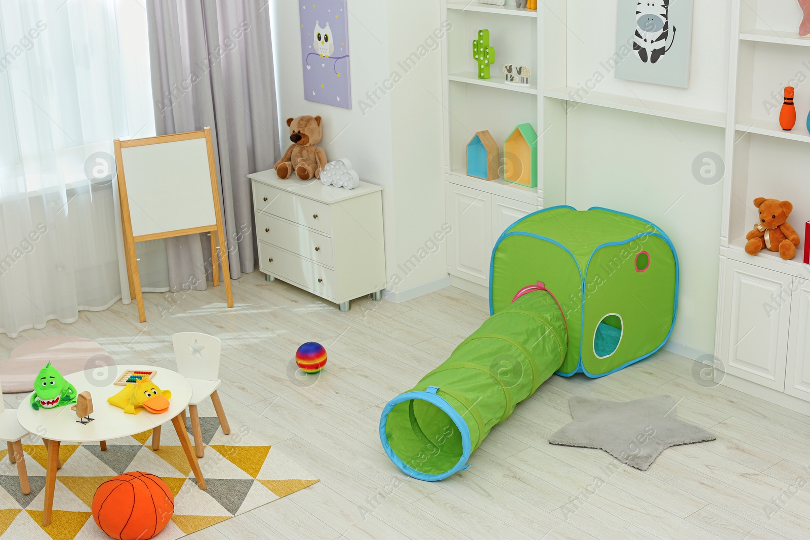 Photo of Child`s playroom with different toys and modern furniture. Stylish kindergarten interior