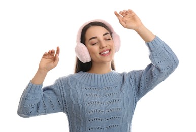 Beautiful young woman wearing earmuffs on white background