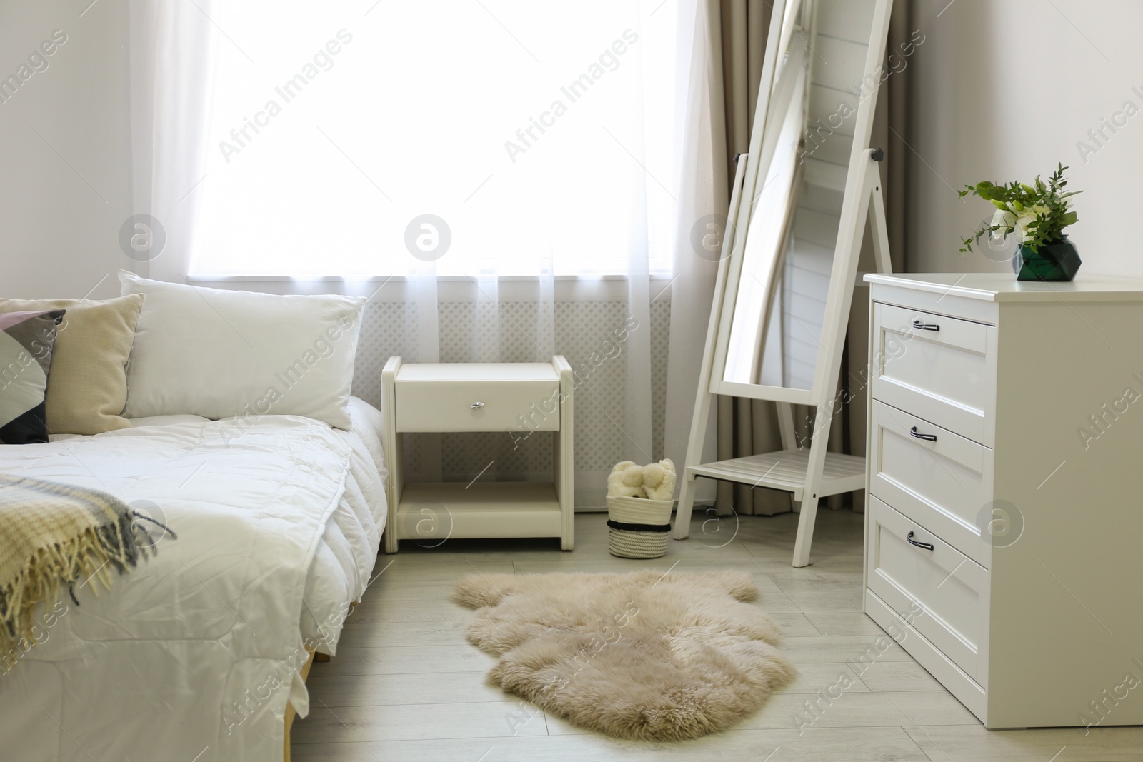 Photo of Bedroom interior with modern chest of drawers and mirror