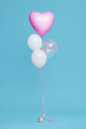 Bunch of heart and round shaped balloons for birthday party on light blue background