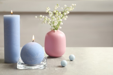 Beautiful composition with burning candles and flowers on table