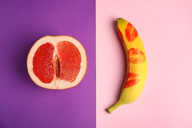 Flat lay composition with fresh banana and grapefruit on color background. Sex concept