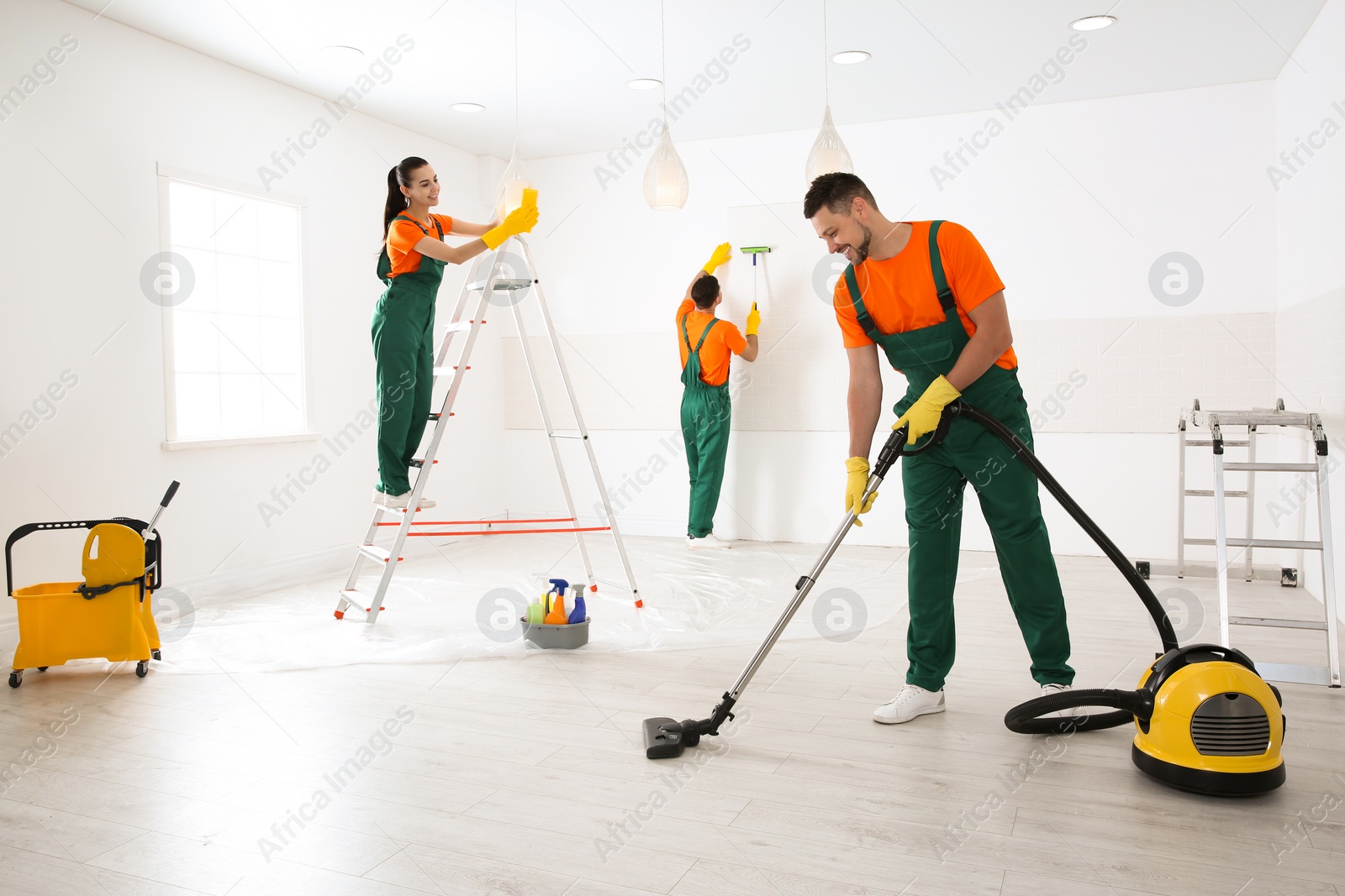 Photo of Team of professional janitors cleaning room after renovation