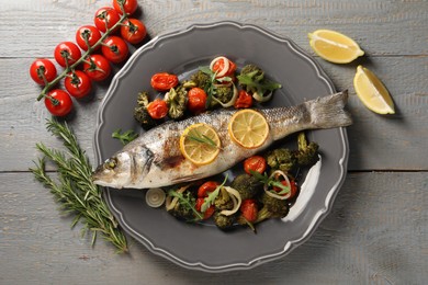 Photo of Baked fish with vegetables, rosemary and lemon on grey wooden table, flat lay