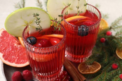 Photo of Aromatic Christmas Sangria in glasses served on table, closeup