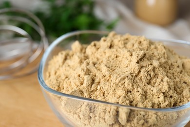 Photo of Bowl of aromatic mustard powder on table, closeup