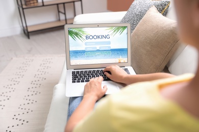 Woman booking tickets online indoors, closeup. Travel agency concept