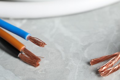 Colorful electrical wires on gray textured surface, closeup