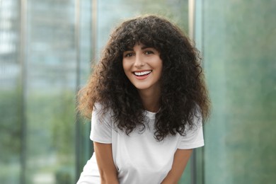 Portrait of beautiful woman posing on blurred background. Attractive lady smiling and looking into camera