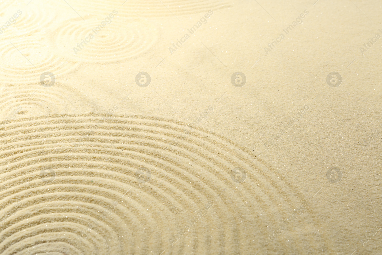 Photo of Zen rock garden. Circle pattern on beige sand, closeup