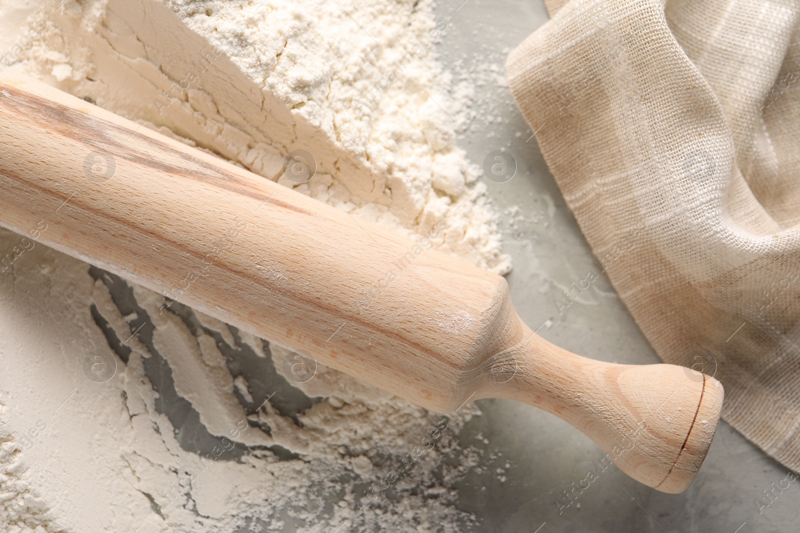 Photo of Pile of flour and rolling pin on grey marble table, top view