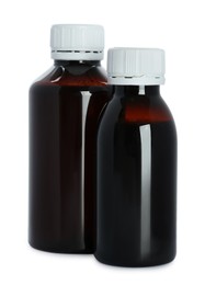 Photo of Bottles of cough syrup on white background