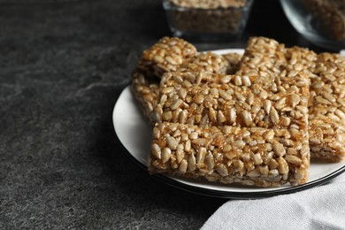 Photo of Delicious sweet kozinaki bars on grey table, closeup. Space for text