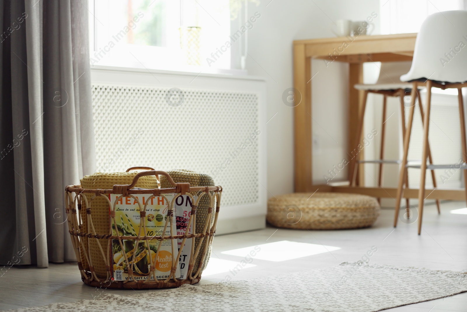 Photo of Basket with soft plaids in modern room interior