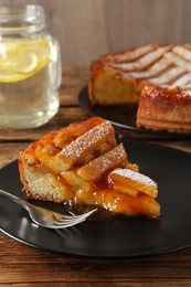 Photo of Piece of tasty apricot pie on wooden table, closeup