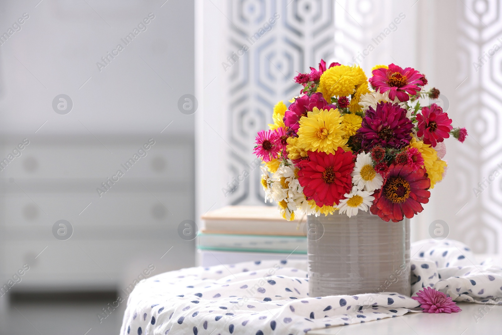 Photo of Vase with beautiful bouquet and cloth on white table in room. Space for text