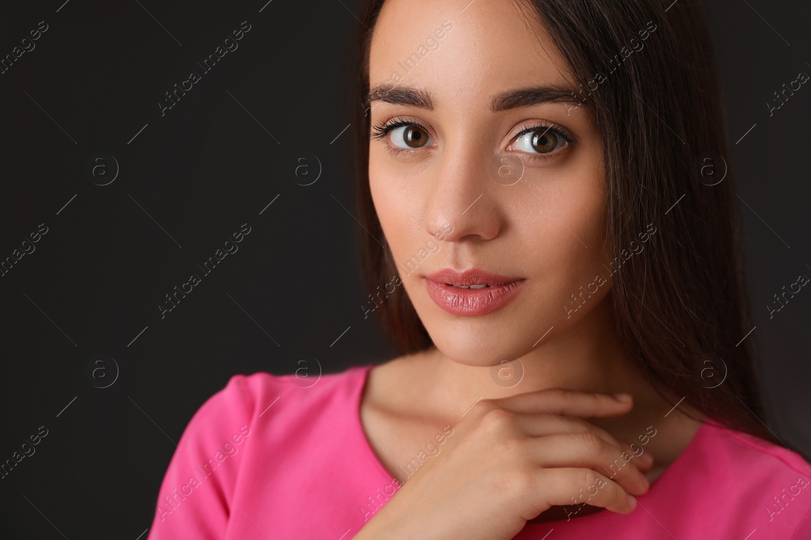 Photo of Portrait of beautiful young woman on dark grey background, closeup