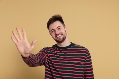 Photo of Man giving high five on beige background