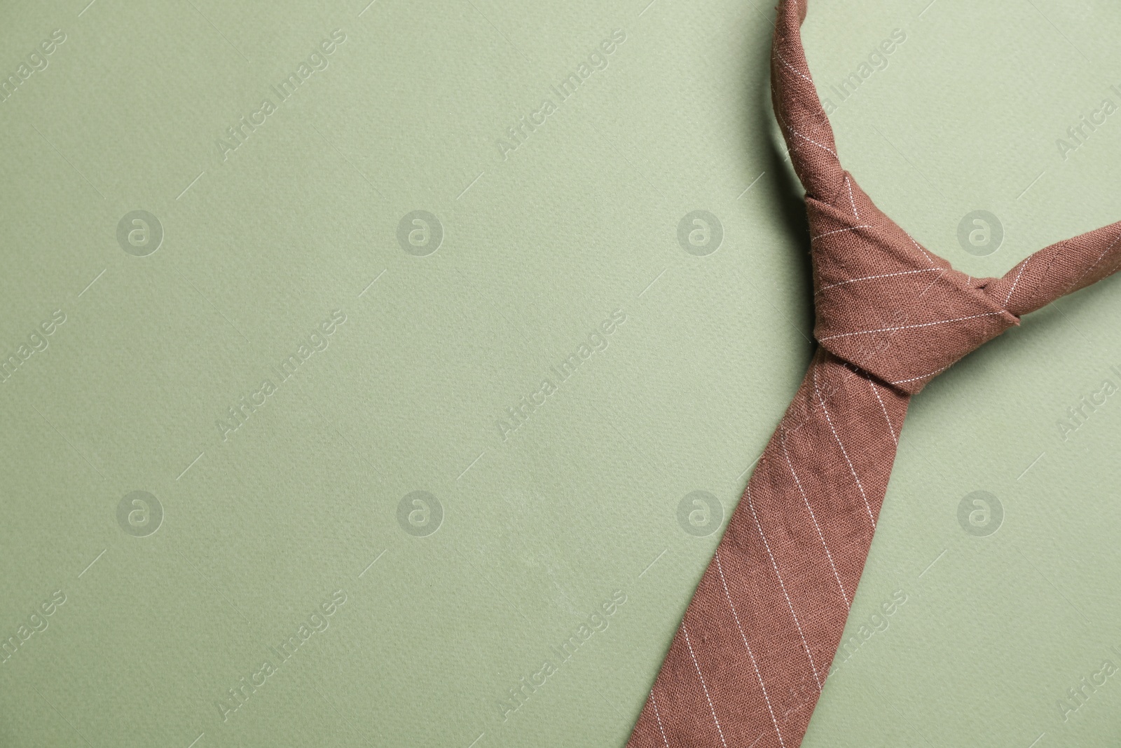 Photo of Stylish necktie on light green background, top view. Space for text