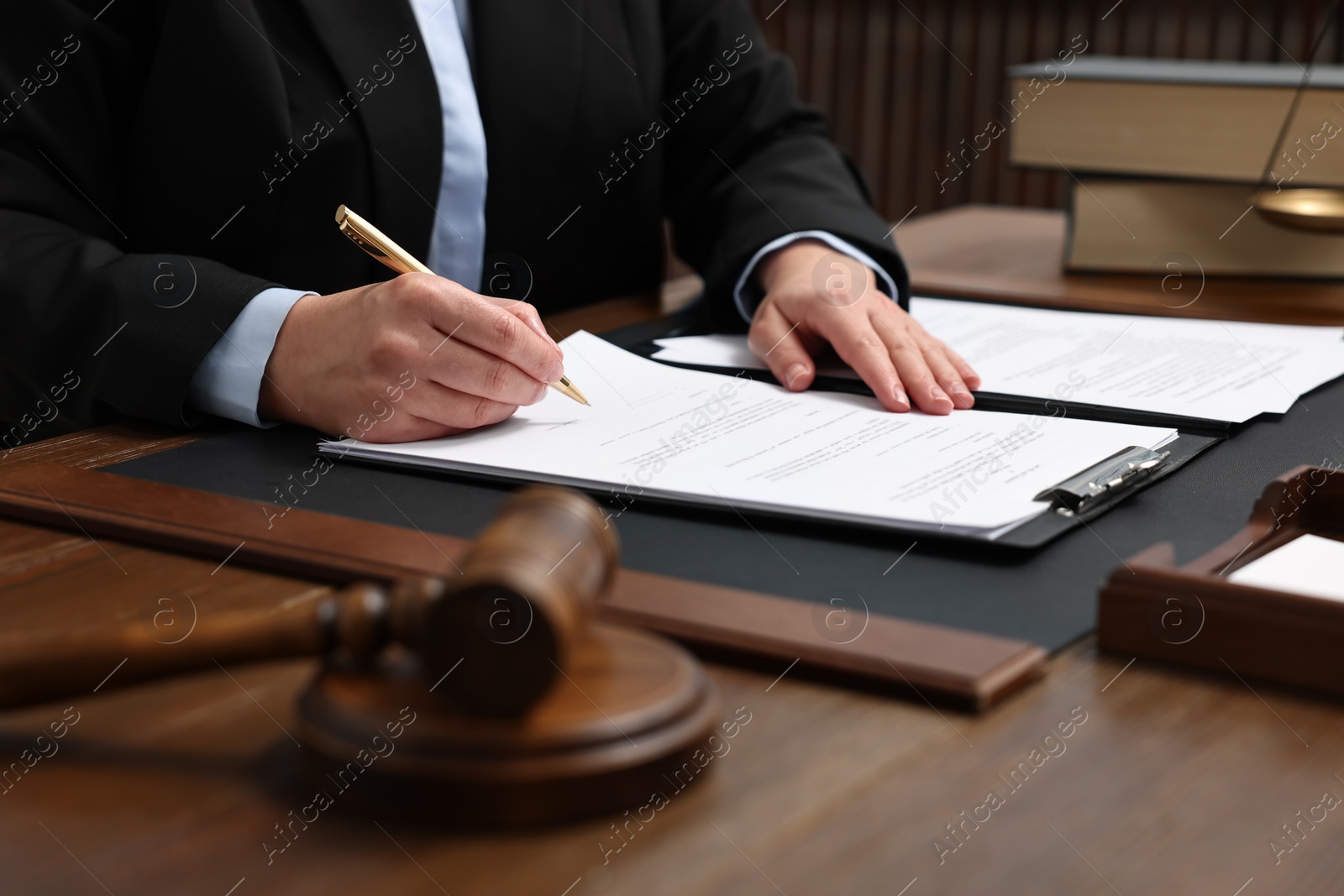 Photo of Lawyer working with documents at wooden table indoors, closeup