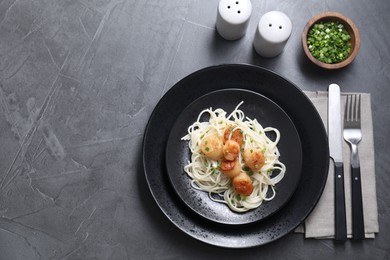 Photo of Delicious scallop pasta with green onion served on grey table, flat lay. Space for text