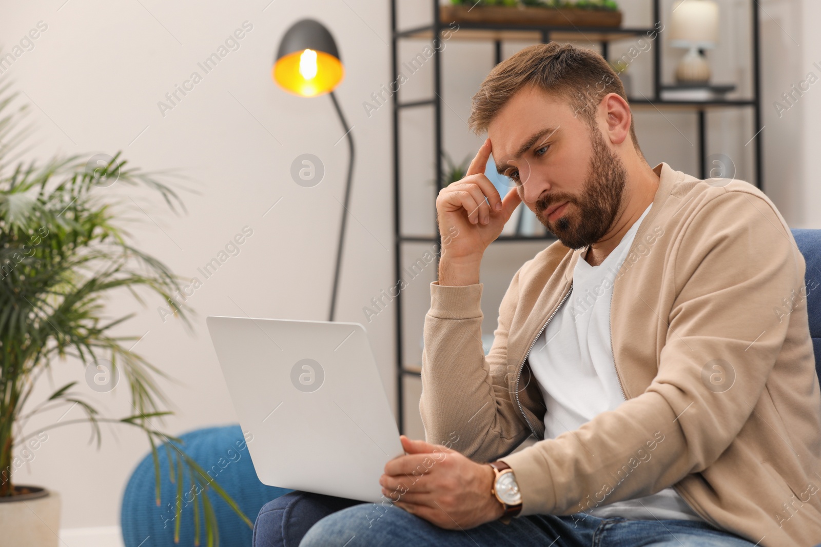 Photo of Young man working with laptop at home