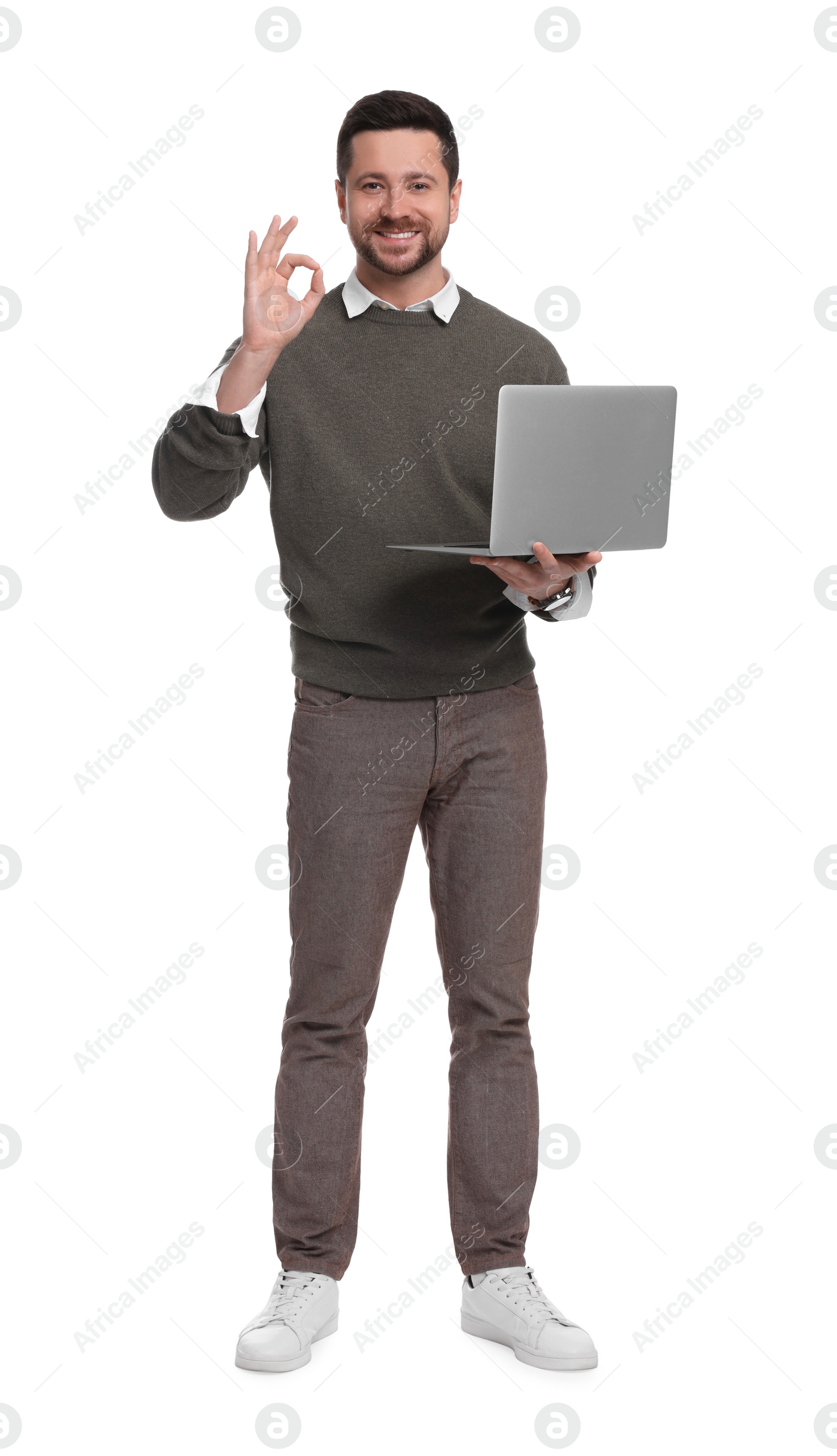 Photo of Handsome bearded businessman with laptop showing OK gesture on white background