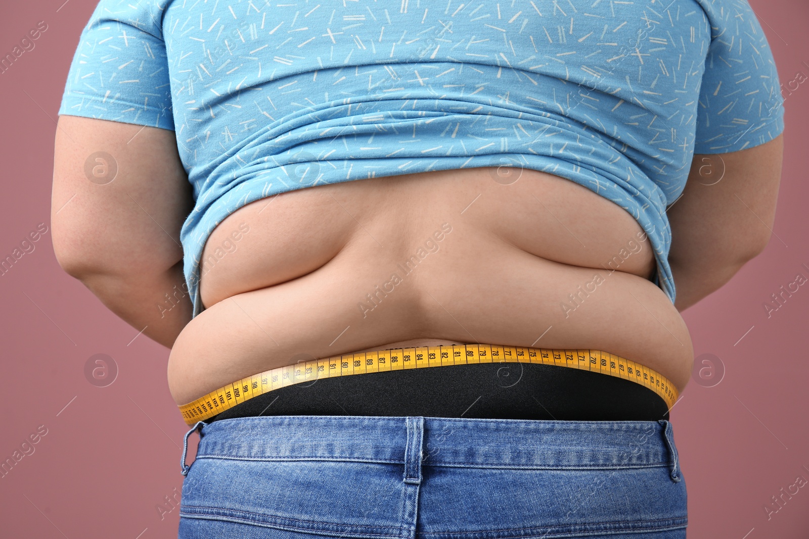 Photo of Overweight woman with measuring tape on color background